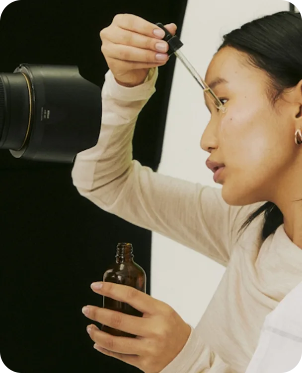 Content creator filming herself applying a facial oil dropper, for Selfnamed beauty content creators