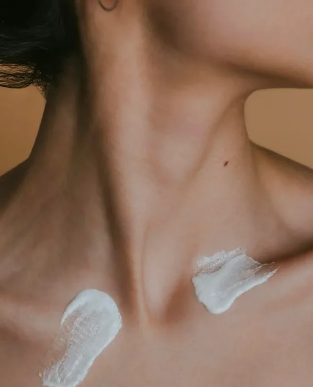 Close-up of skincare cream swatched on a woman's collarbone, for Selfnamed beauty professionals